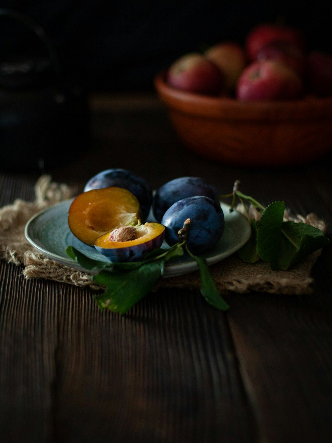 Autumn mushrooms apples and plums on a rustic table